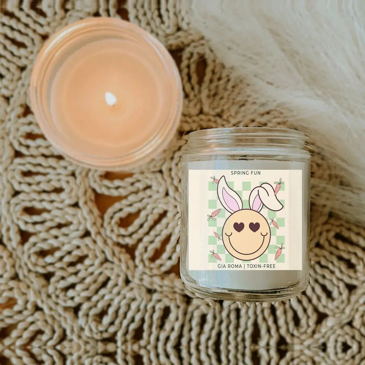 Candle in a glass jar with a decorative label on a textured surface