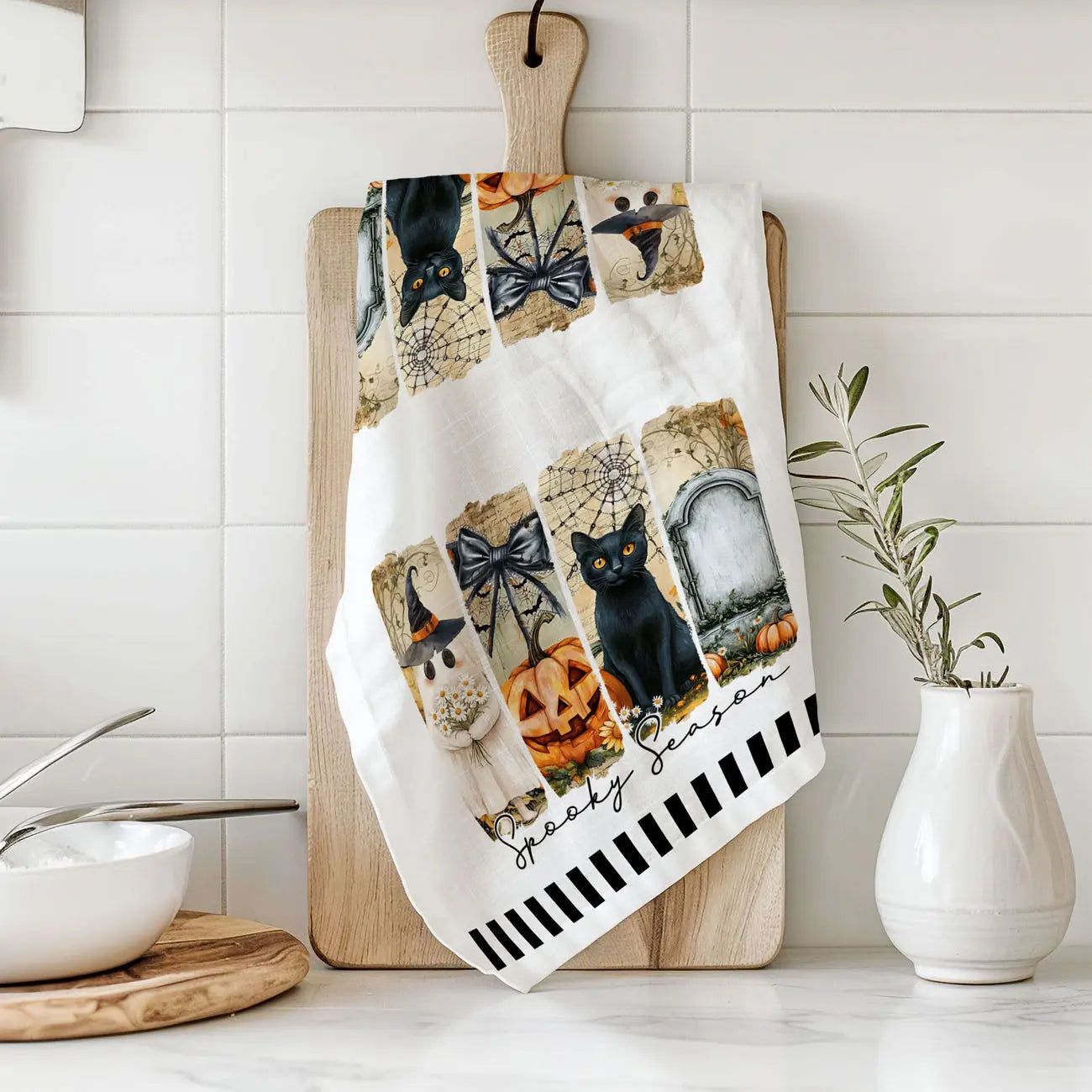 Decorative kitchen towel with Halloween-themed design on a cutting board in a kitchen setting.