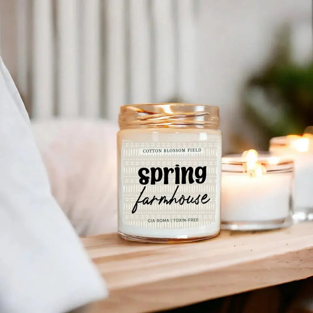 Candle with 'Spring Farmhouse' label on a wooden surface
