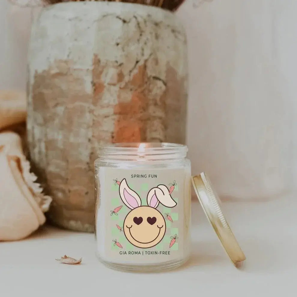 Candle jar with a decorative label featuring a bunny face on a neutral background