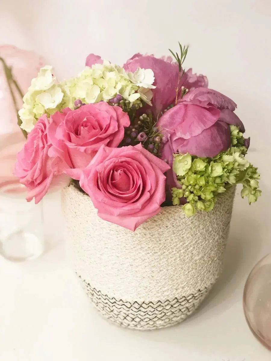 Pink roses and hydrangeas in a woven vase for cozy farmhouse decor