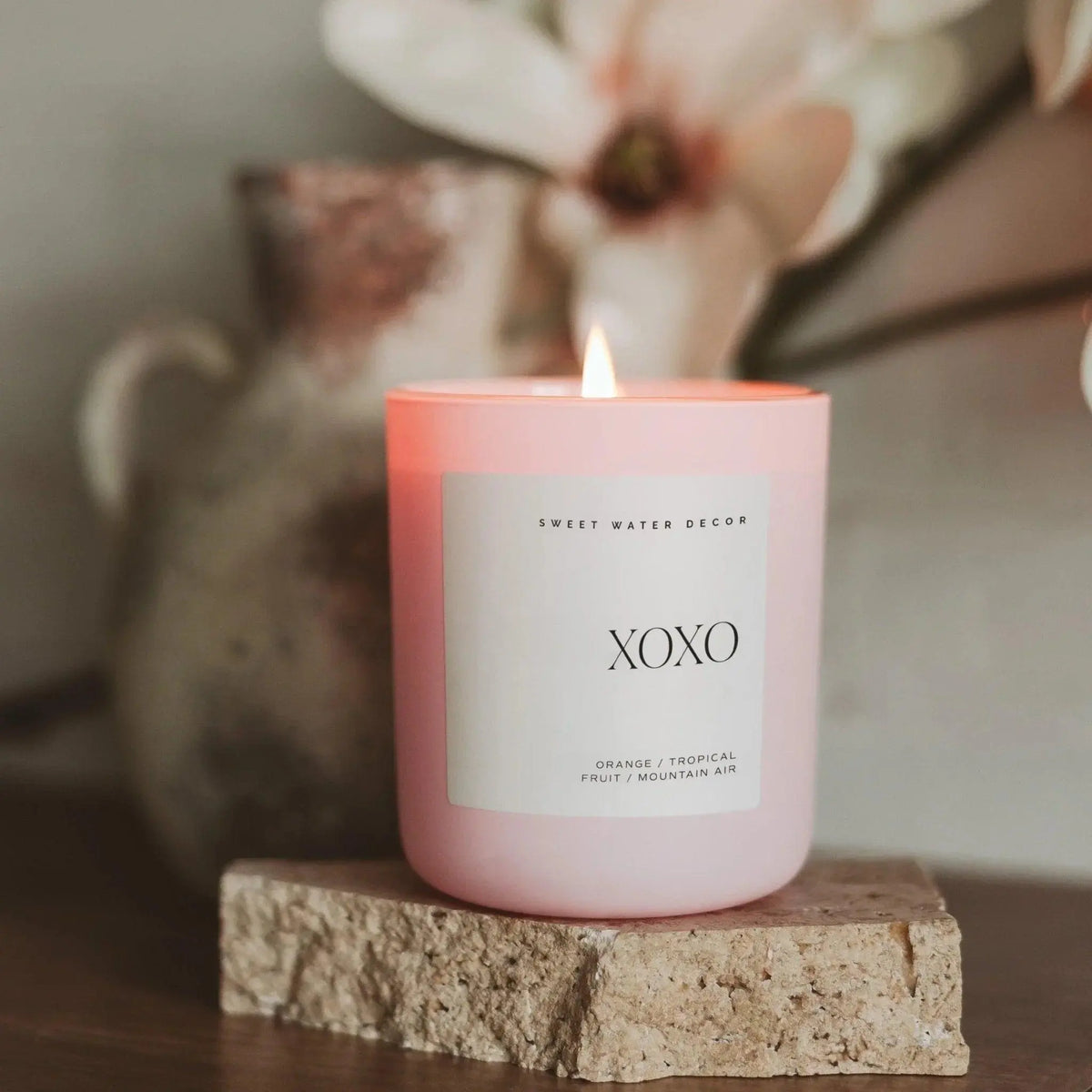 Pink XOXO scented candle with orange tropical fruit notes, cozy farmhouse decor