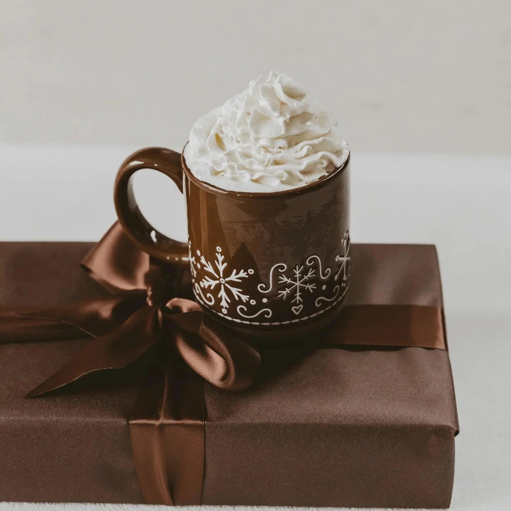 Cozy winter mug with whipped cream, snowflake design, on gift box — perfect farmhouse holiday decor