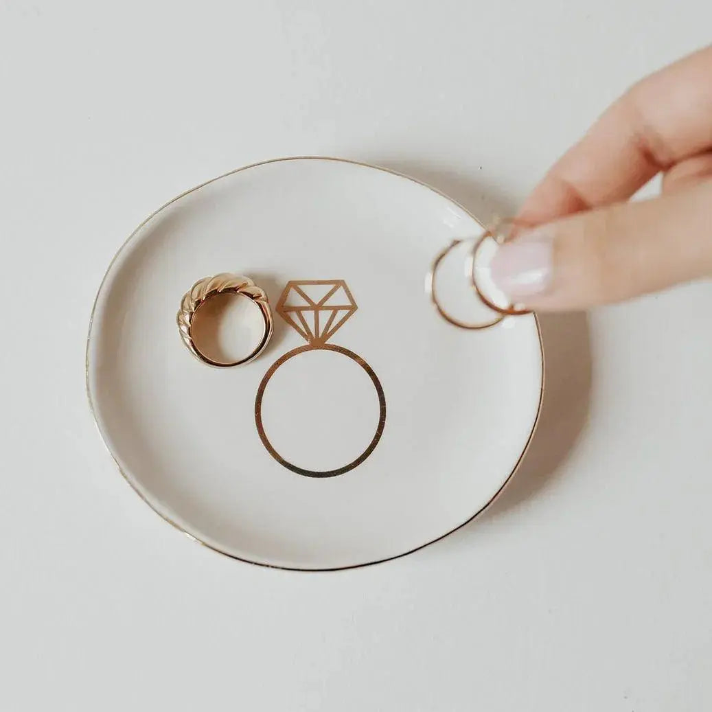 White ceramic ring dish with gold diamond outline, holding gold rings, perfect for farmhouse bathroom decor