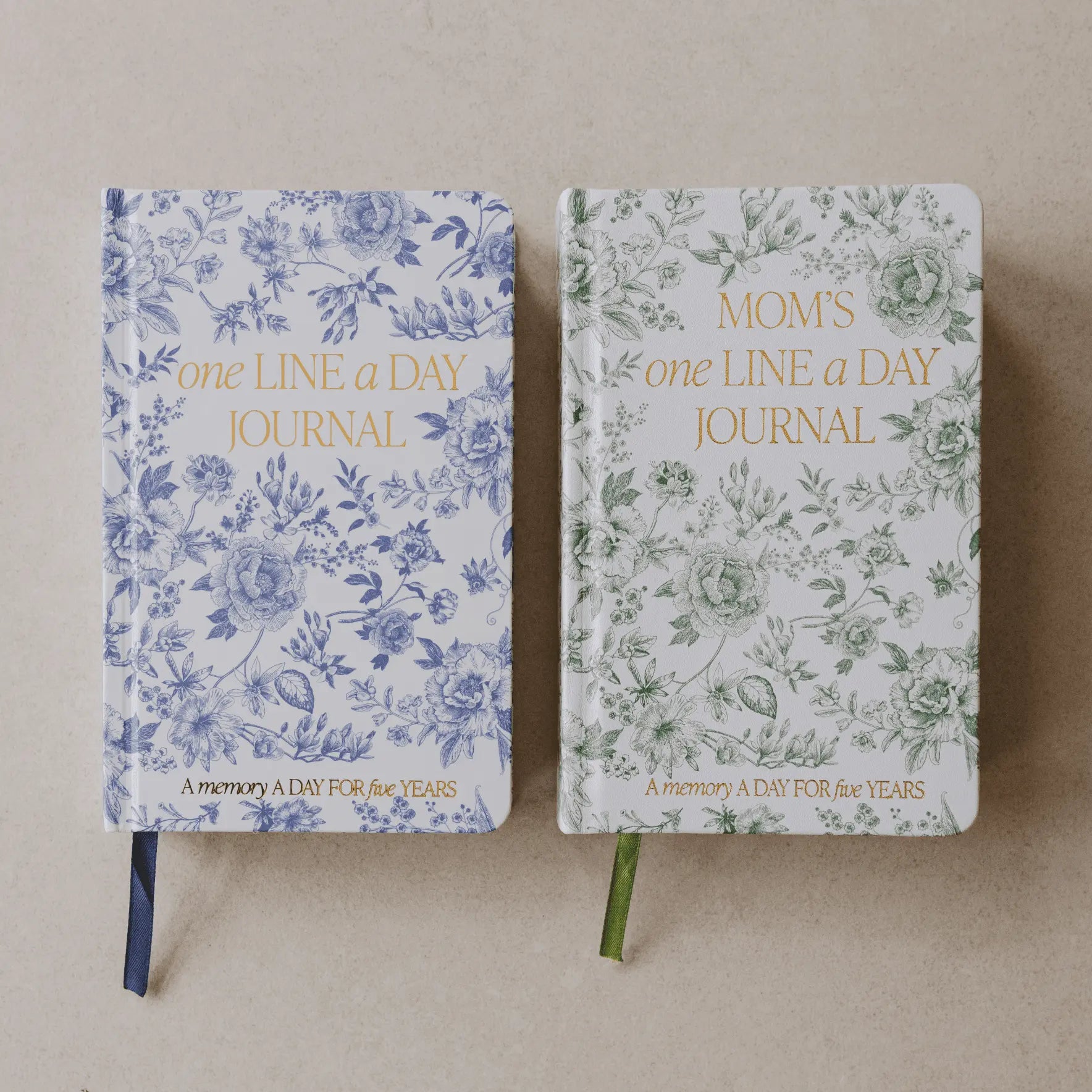 Two floral-patterned journals on stands against a beige background