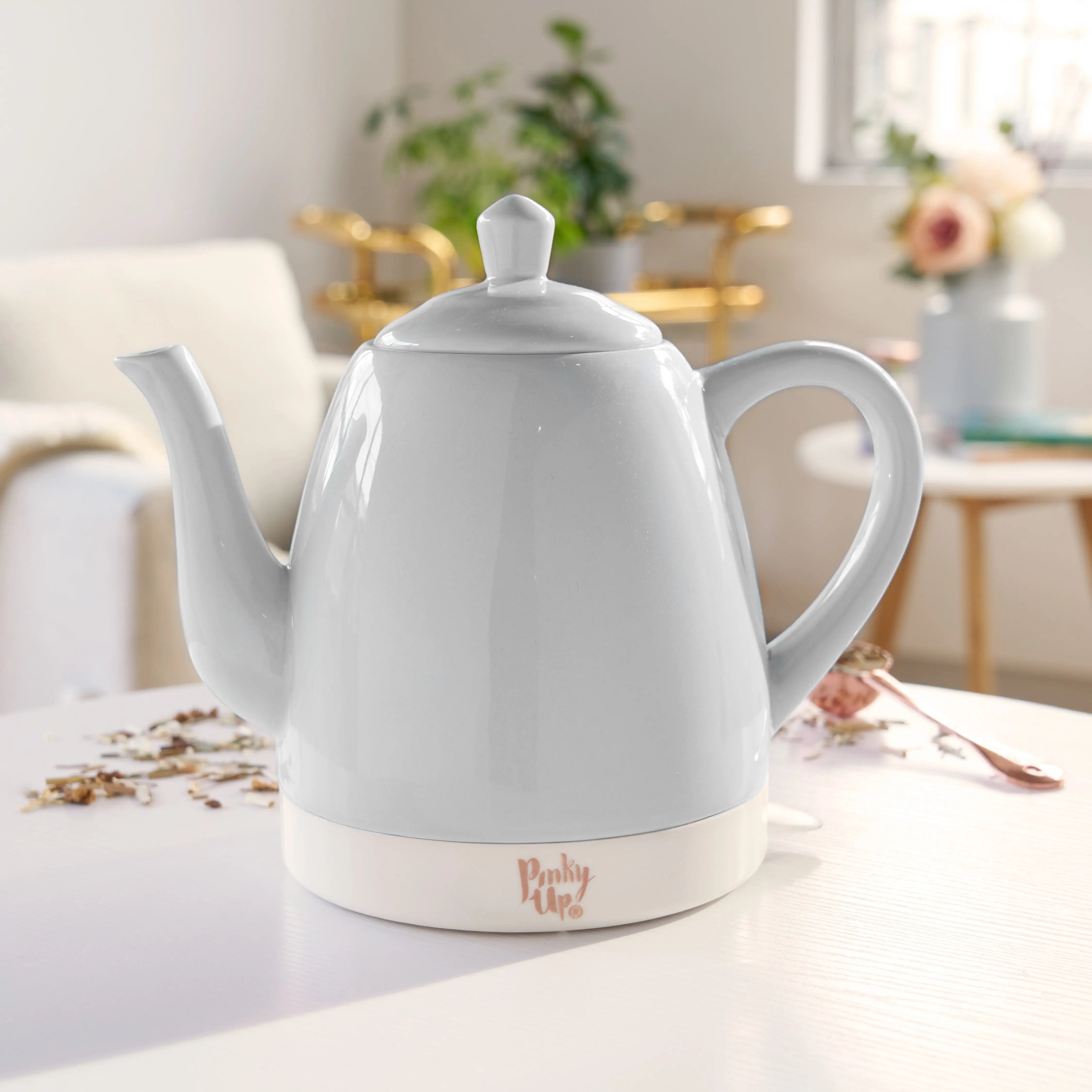 White electric kettle on a kitchen counter with a blurred background