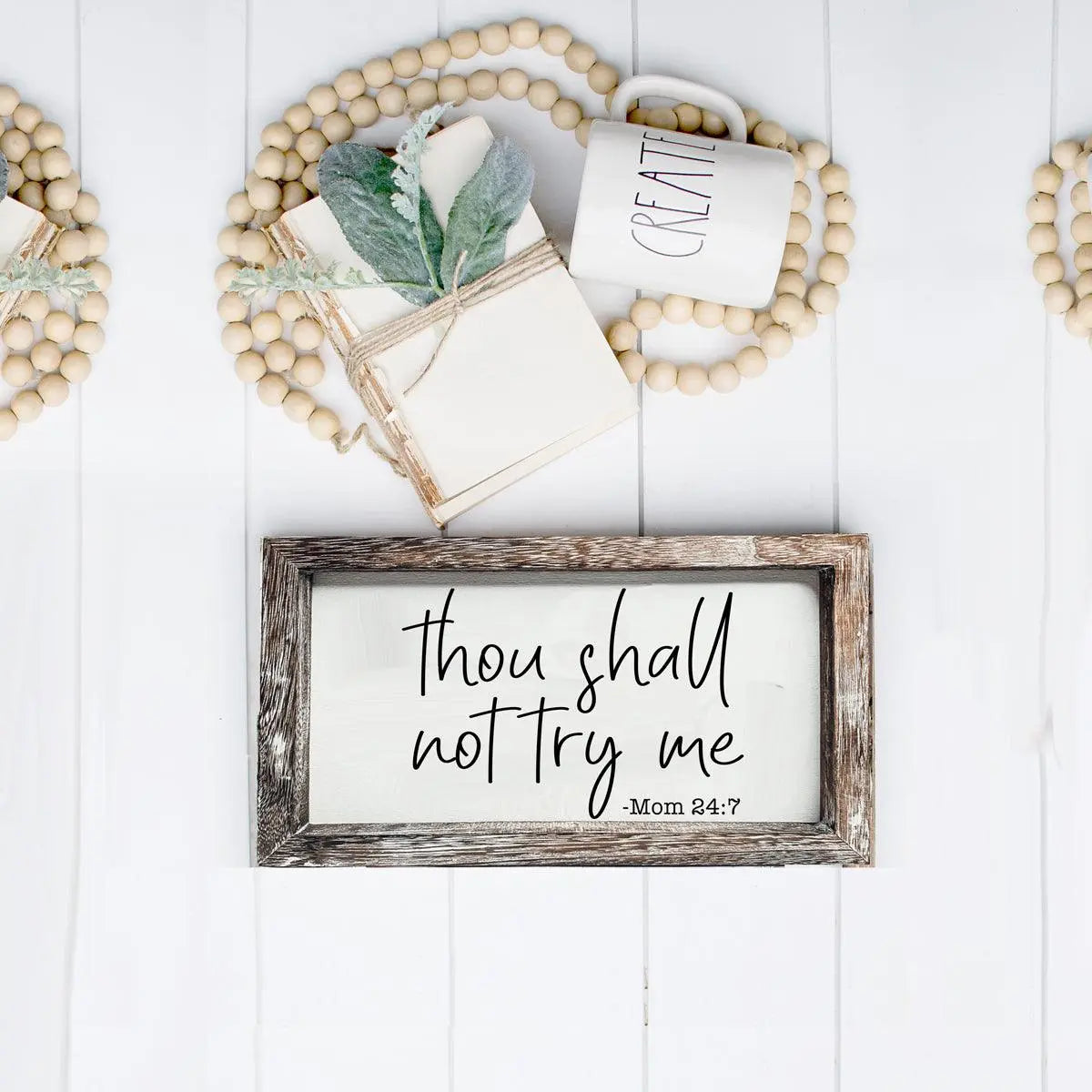 Decorative sign with text on a white wooden background