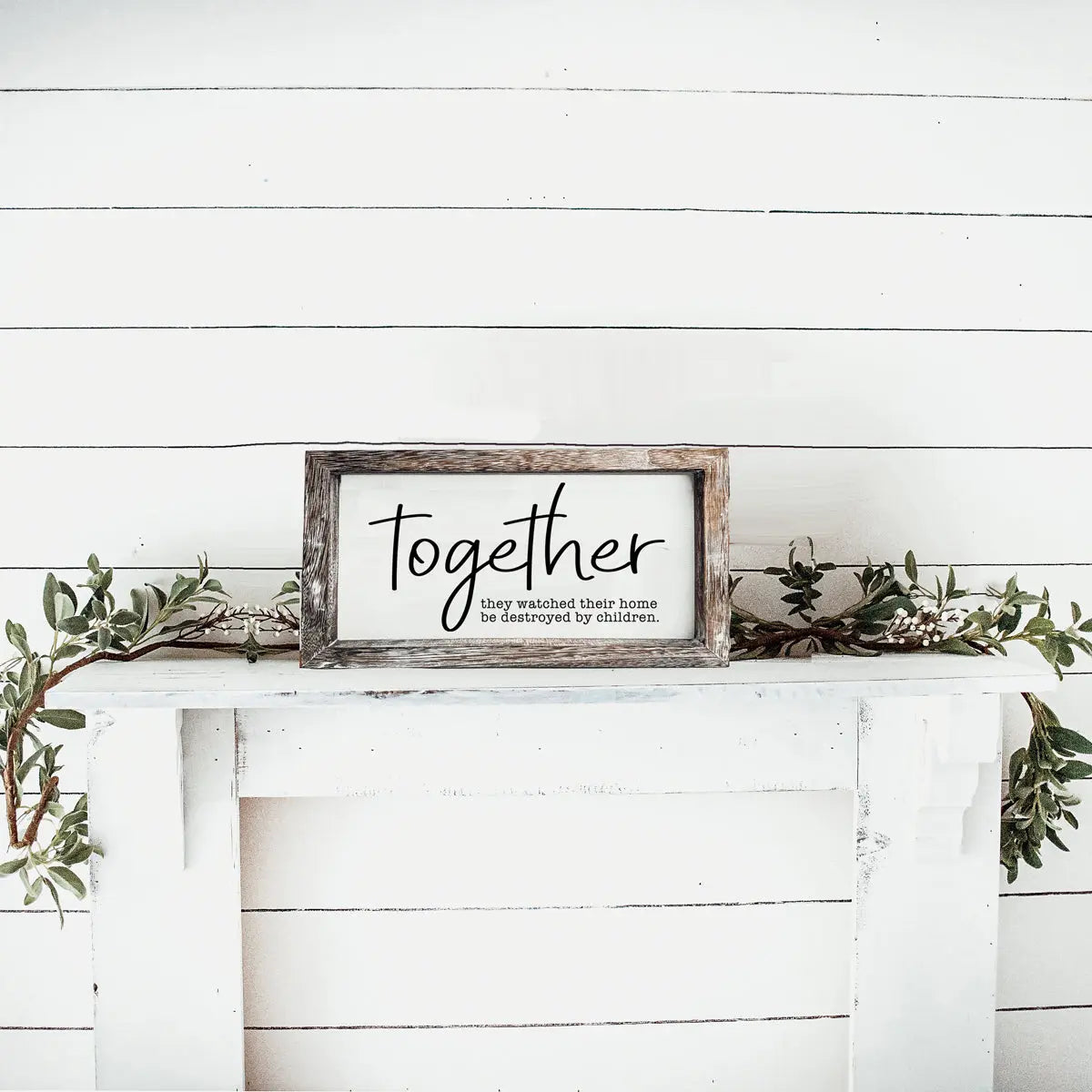 Framed sign with 'thou shall not try me' on a white wooden wall with greenery.