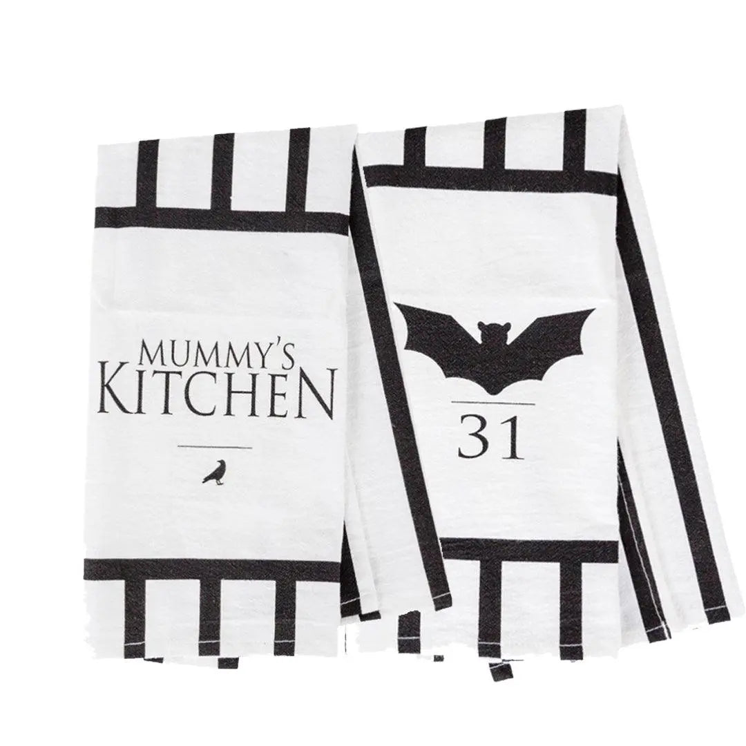 Two black and white kitchen towels with Halloween-themed designs on a white background.