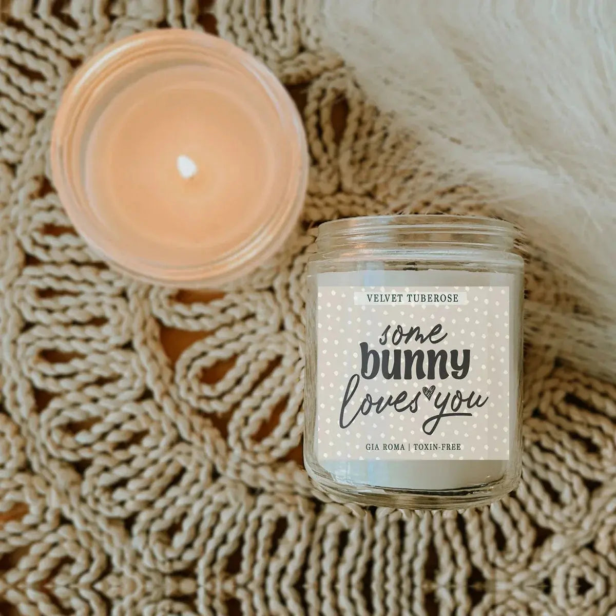 Candle in a glass jar with a label on a textured surface