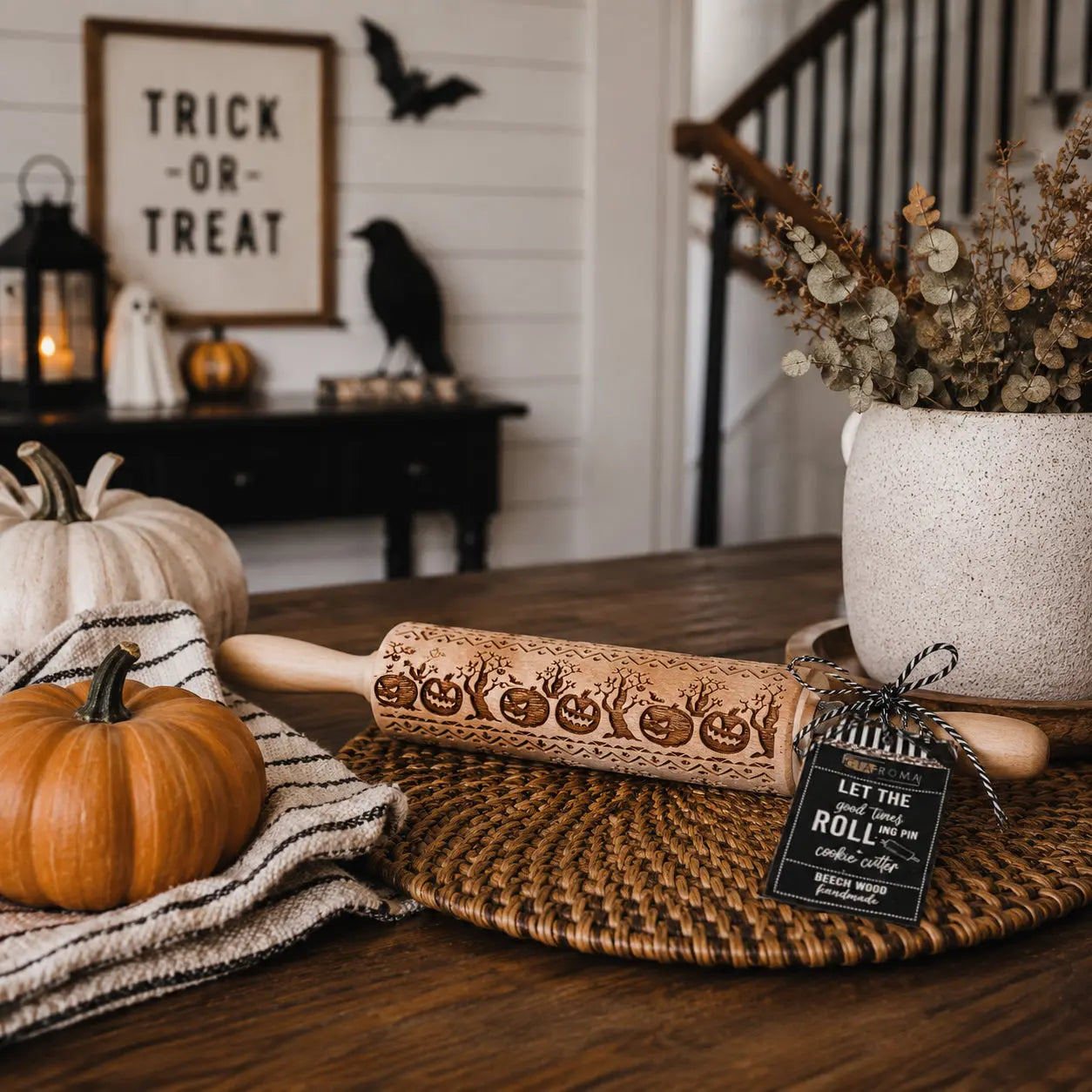 Halloween-themed table setting with pumpkins, a rolling pin, and decorative items.