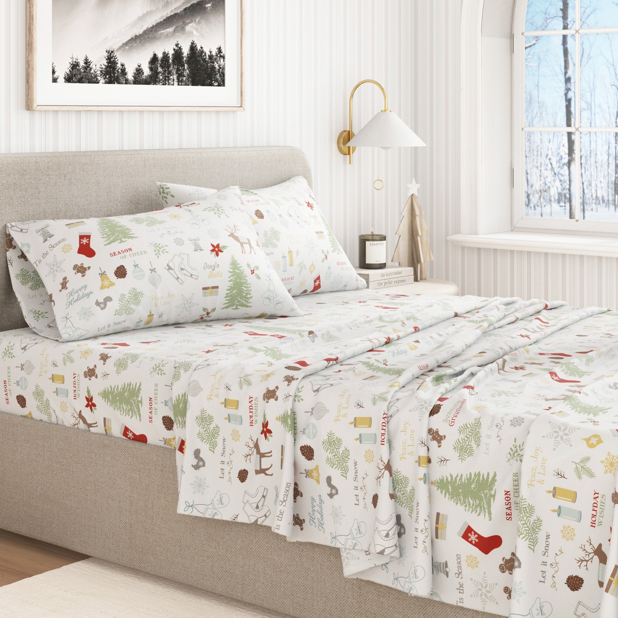 Christmas-themed bedspread on a bed in a bedroom with a window and lamp in the background.